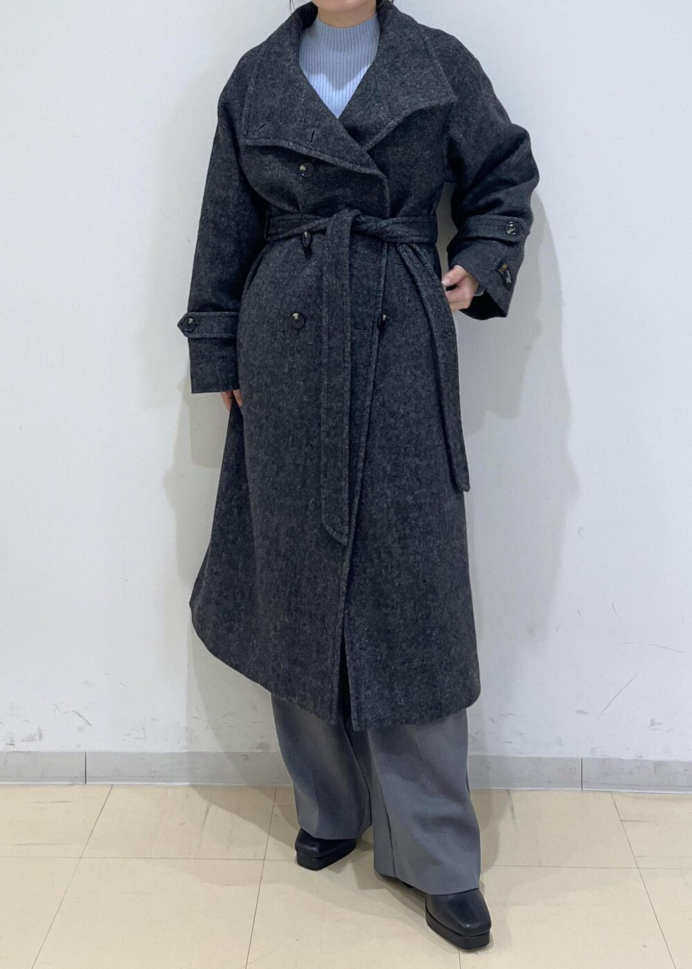 グレー系のスラックス、ホワイト系のベスト、ブルー系のニット/セーターを着用したレディースの秋コーディネートの5枚目の写真