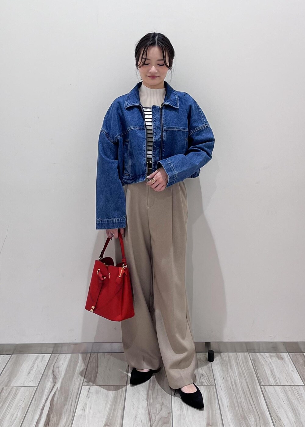 ブルー系のデニムジャケット、ホワイト系のニット/セーター、ベージュ系のスラックスを着用したレディースの冬コーディネートの2枚目の写真