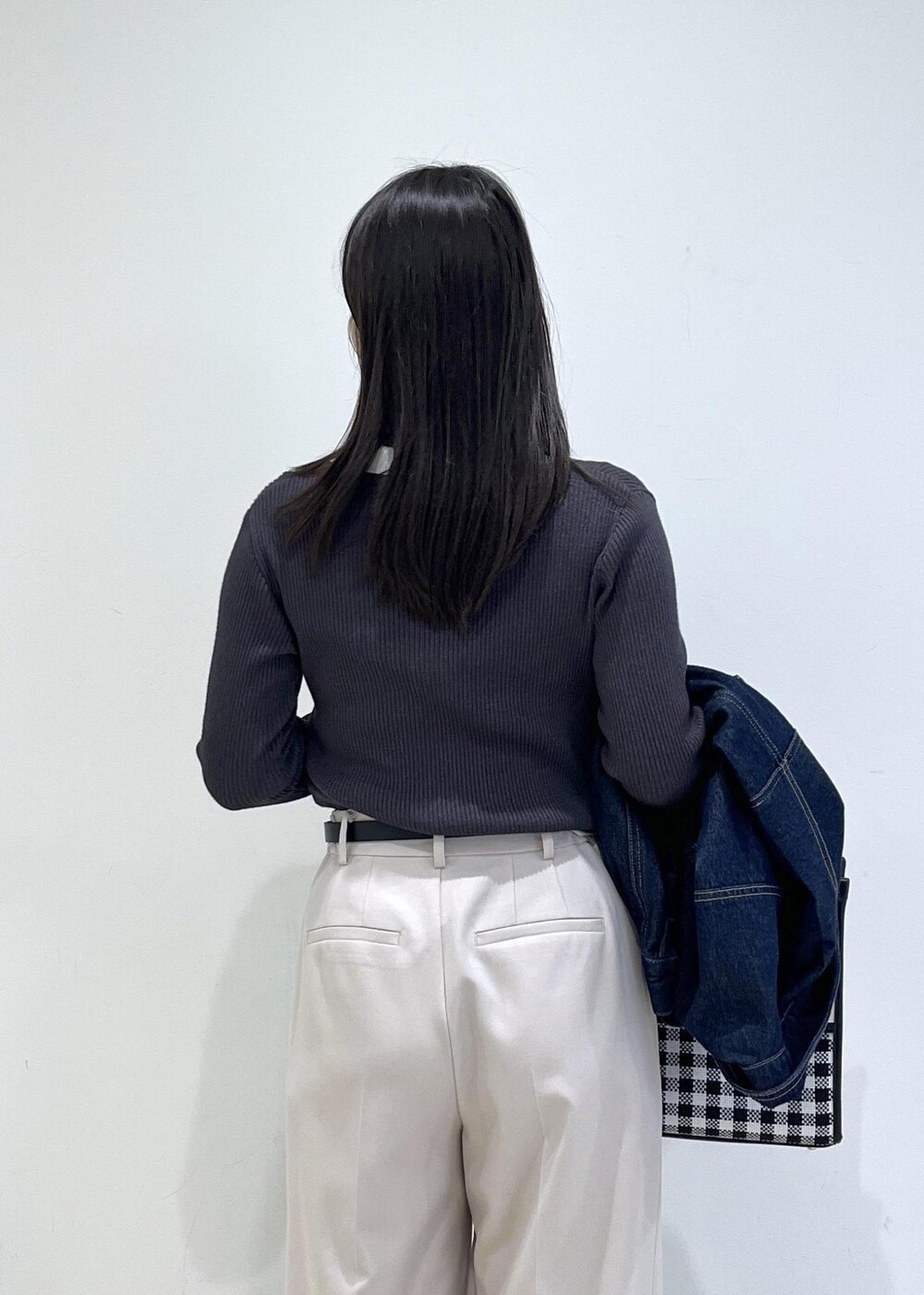 ブルー系のデニムジャケット、グレー系のニット/セーター、ベージュ系のその他パンツを着用したレディースの冬コーディネートの3枚目の写真