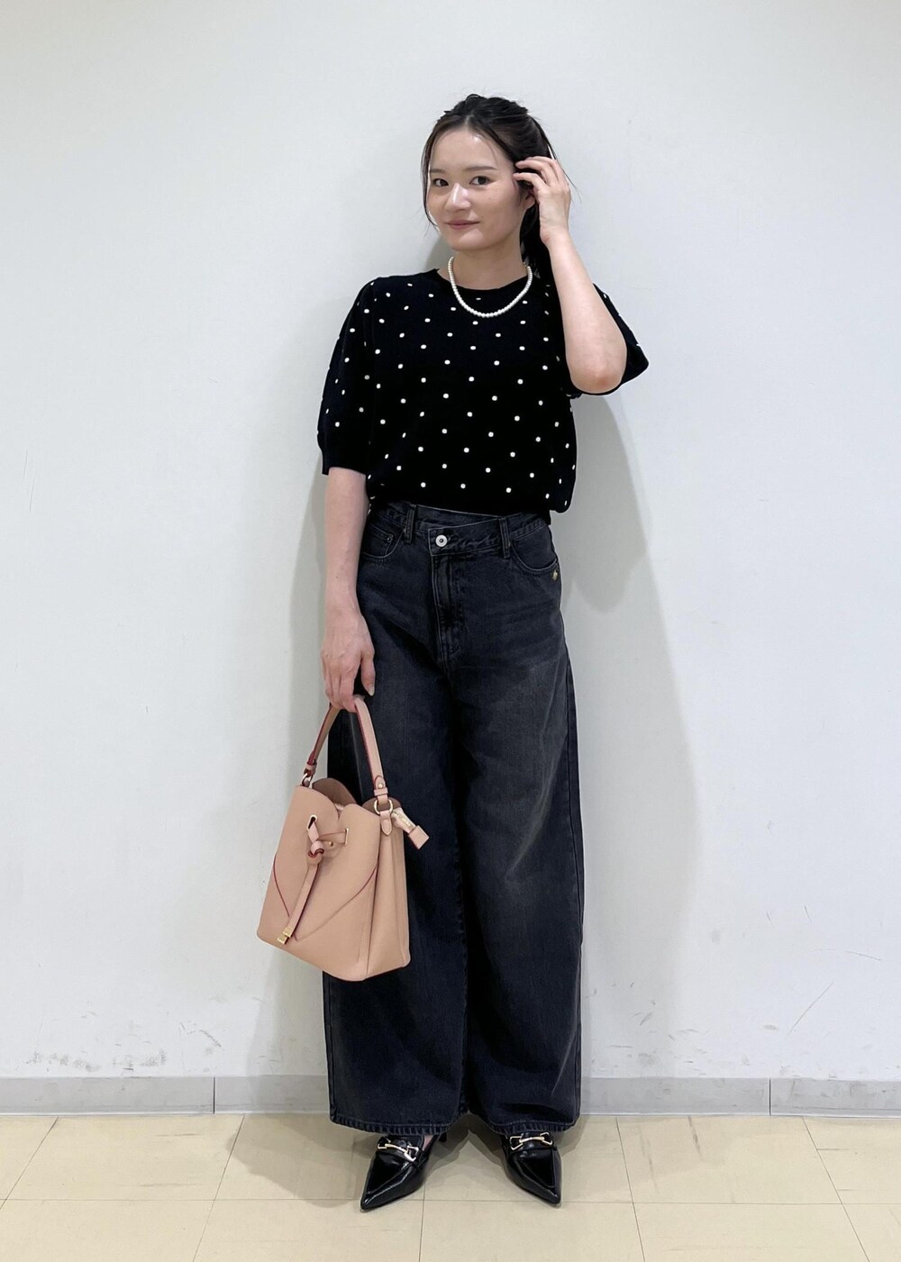 ピンク系のショルダーバッグ、ブラック系のパンプス、ブラック系のニット/セーターを着用したレディースの秋コーディネートの2枚目の写真