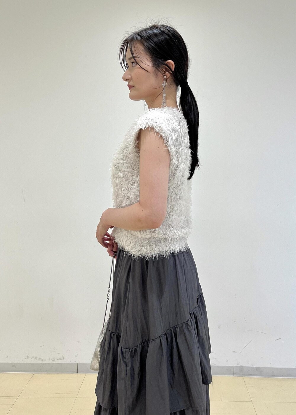 シルバー系のパンプス、シルバー系のショルダーバッグ、グレー系のスカートを着用したレディースの夏コーディネートの6枚目の写真