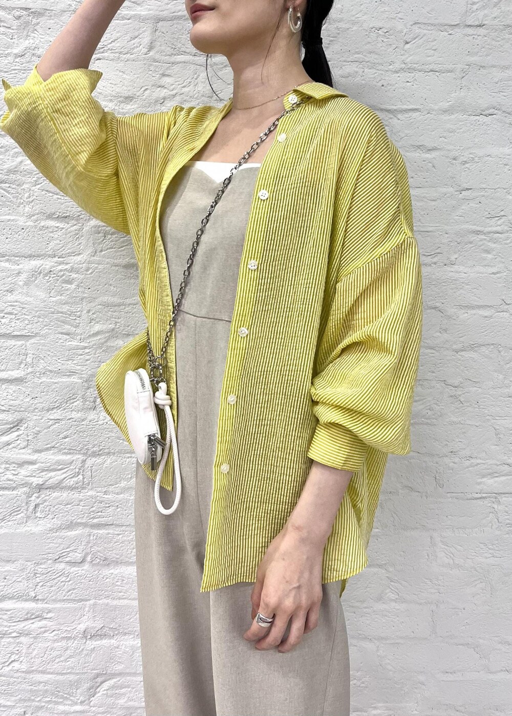 ホワイト系のサンダル、イエロー系のシャツ/ブラウス、ホワイト系のショルダーバッグを着用したレディースの夏コーディネートの4枚目の写真