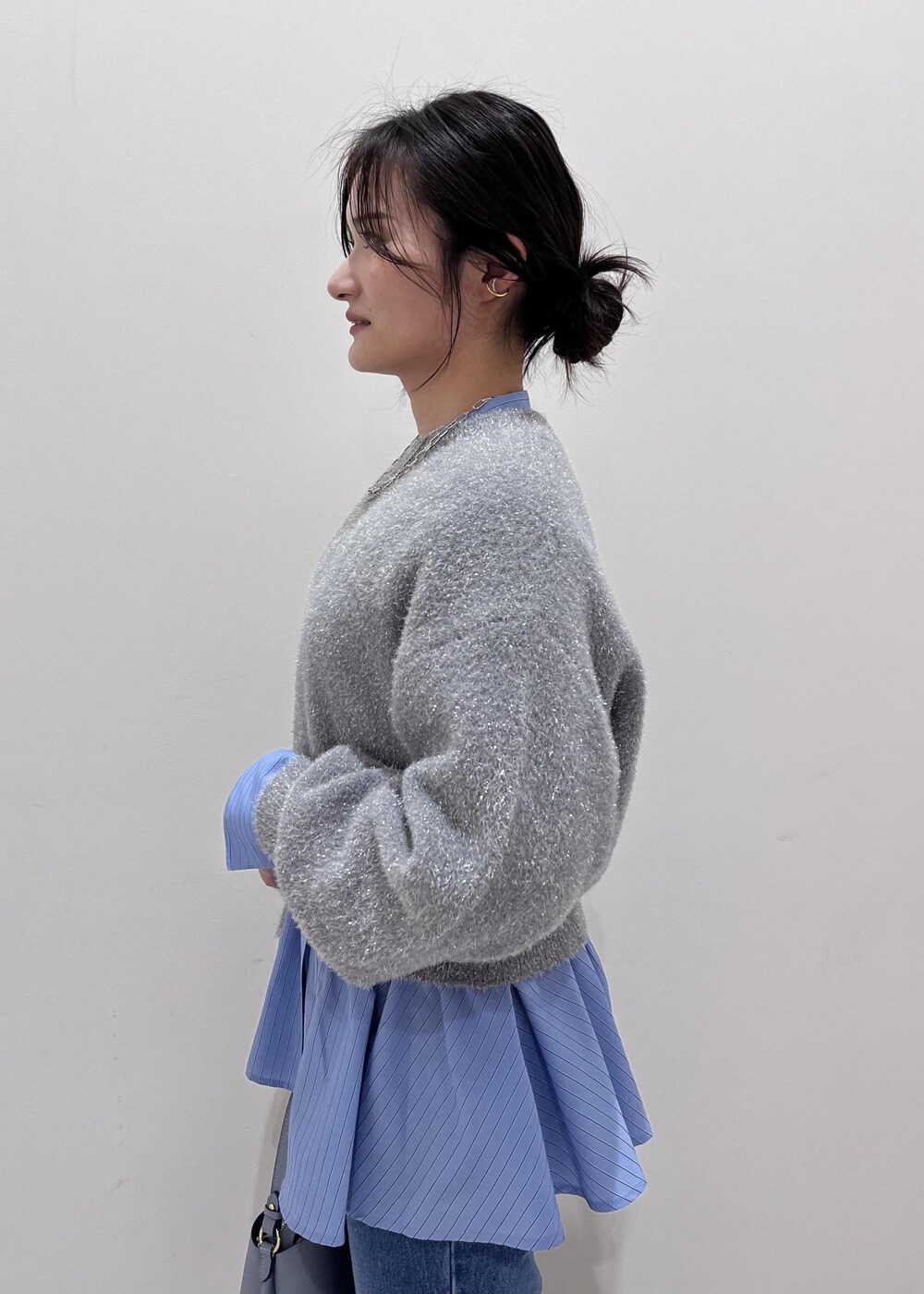 シルバー系のパンプス、ブルー系のデニムパンツ、ブルー系のシャツ/ブラウスを着用したレディースの冬コーディネートの6枚目の写真