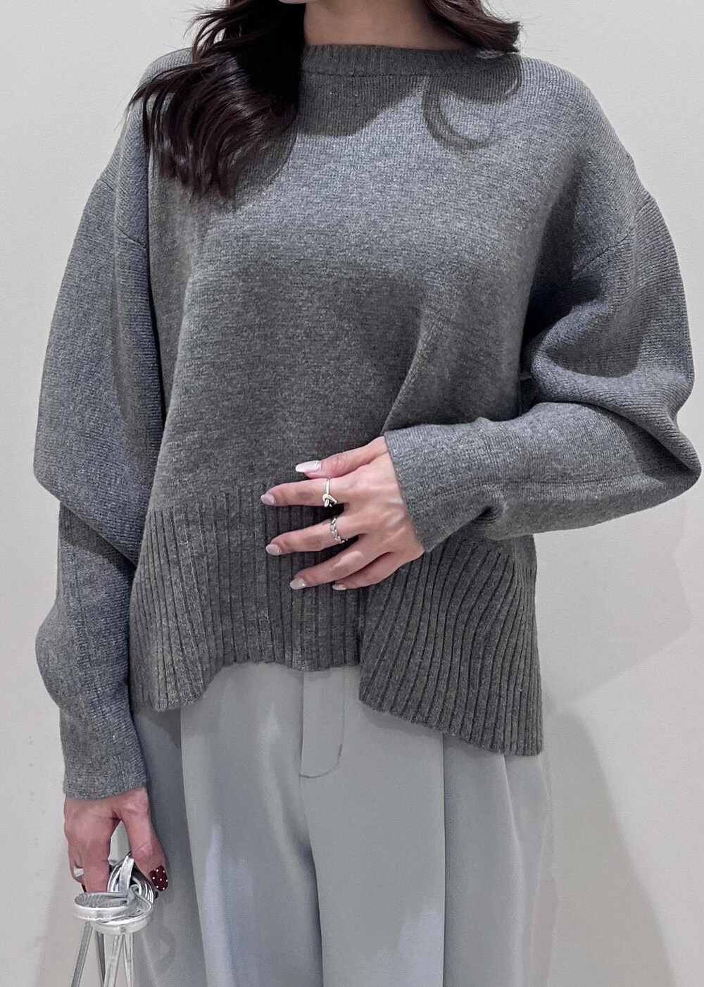 シルバー系のパンプス、シルバー系のショルダーバッグ、ブルー系のスラックスを着用したレディースの秋コーディネートの5枚目の写真