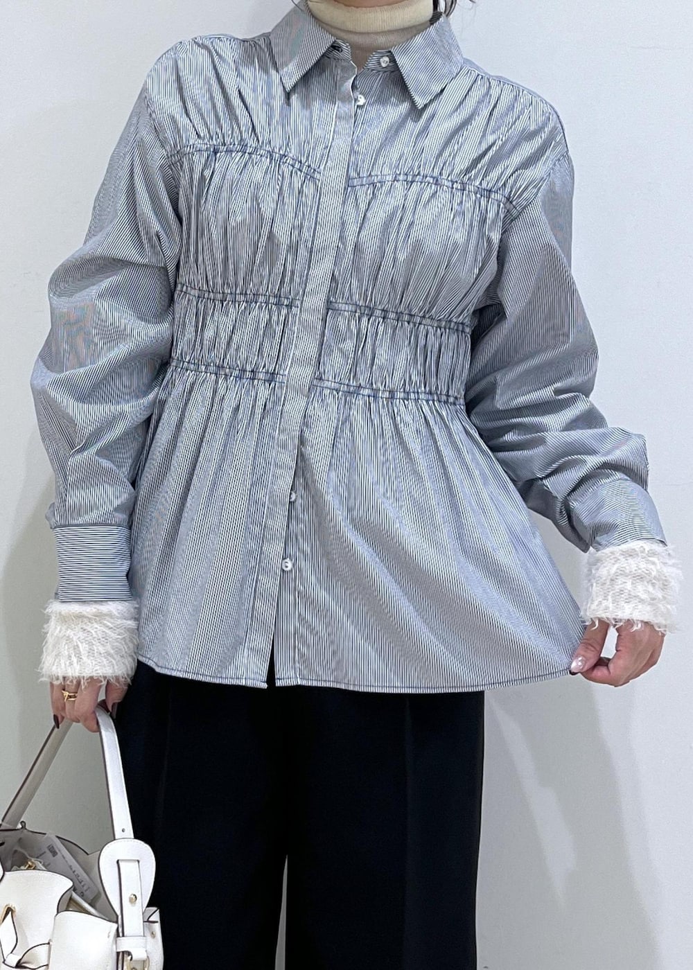 ブラック系のスラックス、ブラック系のテーラードジャケット、ブラック系のパンプスを着用したレディースの秋コーディネートの3枚目の写真