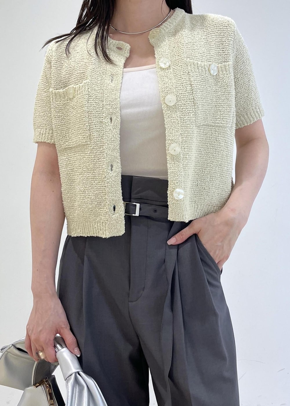 シルバー系のハンドバッグ、シルバー系のパンプス、グリーン系のカーディガン/ボレロを着用したレディースの春コーディネートの6枚目の写真