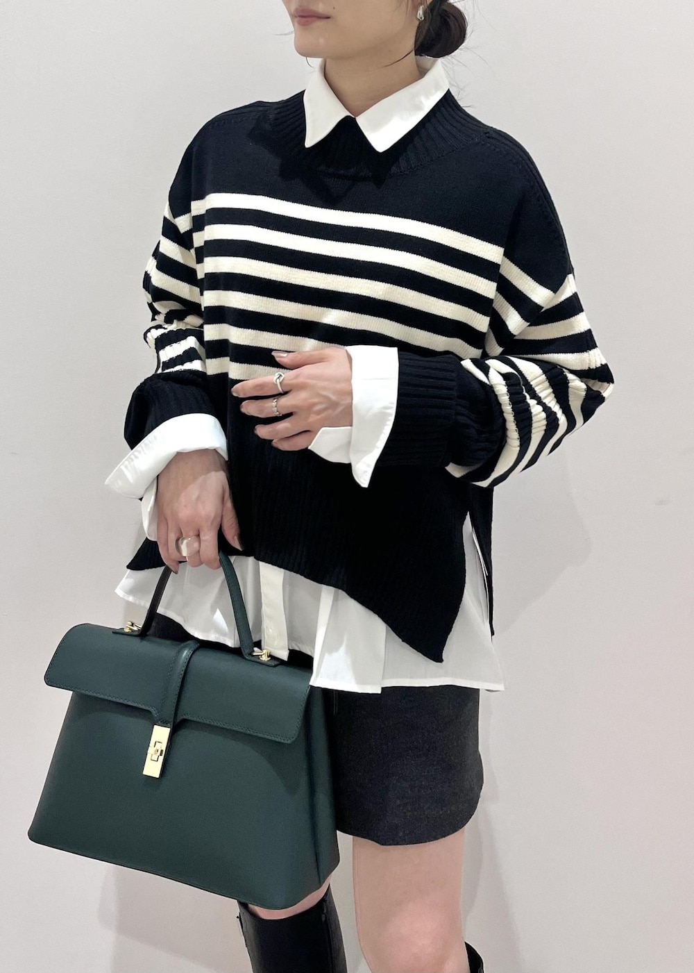 ブラック系のブーツ、ホワイト系のシャツ/ブラウス、ブラック系のニット/セーターを着用したレディースの秋コーディネートの7枚目の写真