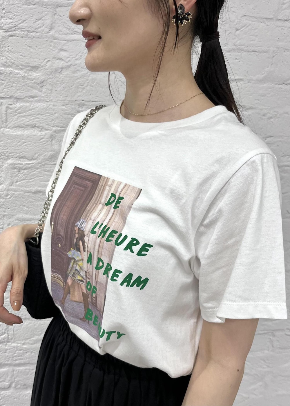 グリーン系のサンダル、ブラック系のショルダーバッグ、ホワイト系のTシャツ/カットソーを着用したレディースの夏コーディネートの2枚目の写真