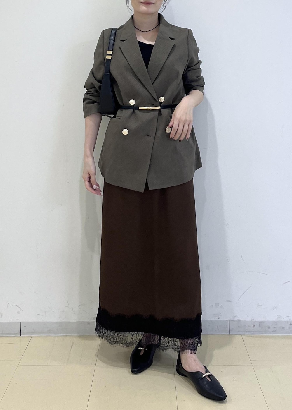 ブラック系のショルダーバッグ、ブラック系のパンプス、グリーン系のテーラードジャケットを着用したレディースの秋コーディネートの9枚目の写真