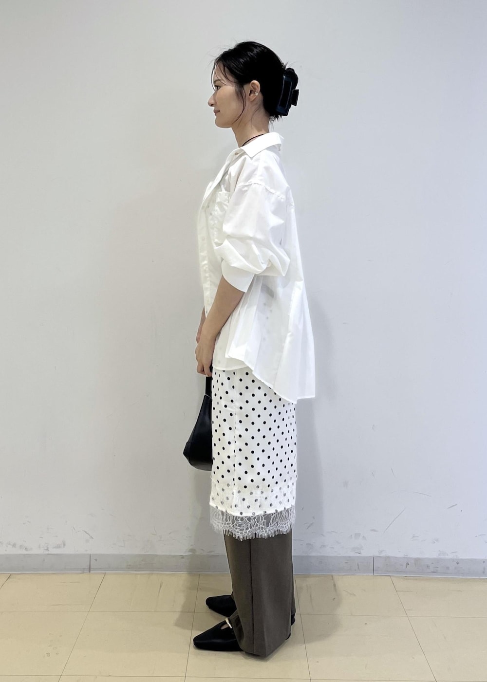 ブラック系のパンプス、グリーン系のその他パンツ、ホワイト系のスカートを着用したレディースの秋コーディネートの2枚目の写真