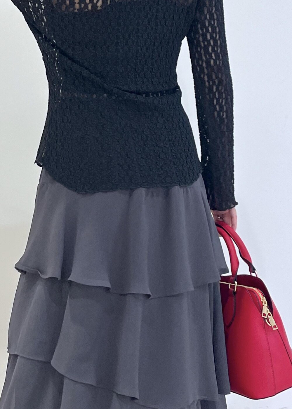 ブラック系のカーディガン/ボレロ、レッド系のボストンバッグ、グレー系のスカートを着用したレディースの秋コーディネートの8枚目の写真