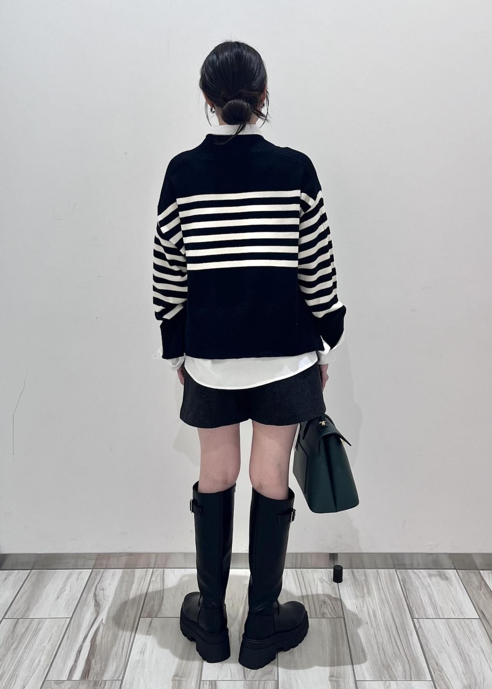 ブラック系のブーツ、ホワイト系のシャツ/ブラウス、ブラック系のニット/セーターを着用したレディースの秋コーディネートの5枚目の写真