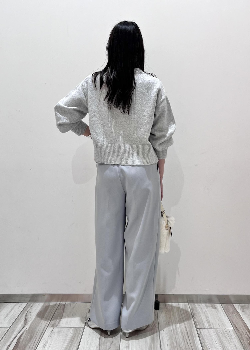 シルバー系のパンプス、ホワイト系のショルダーバッグ、グレー系のカーディガン/ボレロを着用したレディースの秋コーディネートの4枚目の写真