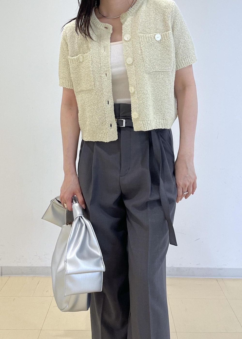 シルバー系のハンドバッグ、シルバー系のパンプス、グリーン系のカーディガン/ボレロを着用したレディースの春コーディネートの5枚目の写真