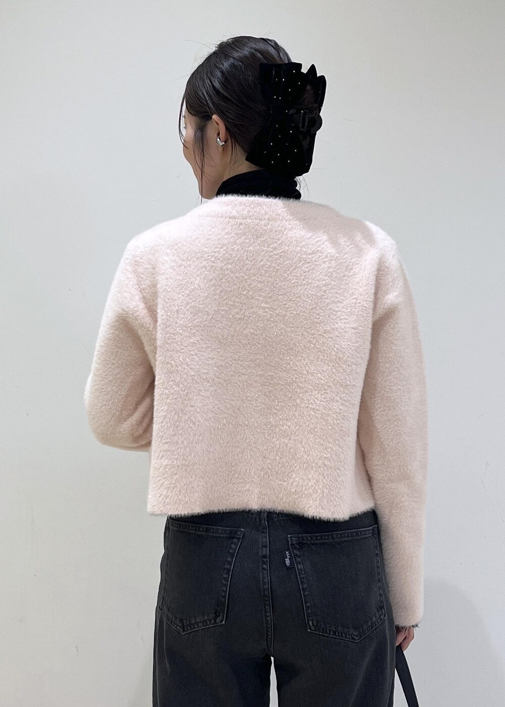 ブラック系のショルダーバッグ、グレー系のデニムパンツ、ピンク系のカーディガン/ボレロを着用したレディースの秋コーディネートの6枚目の写真