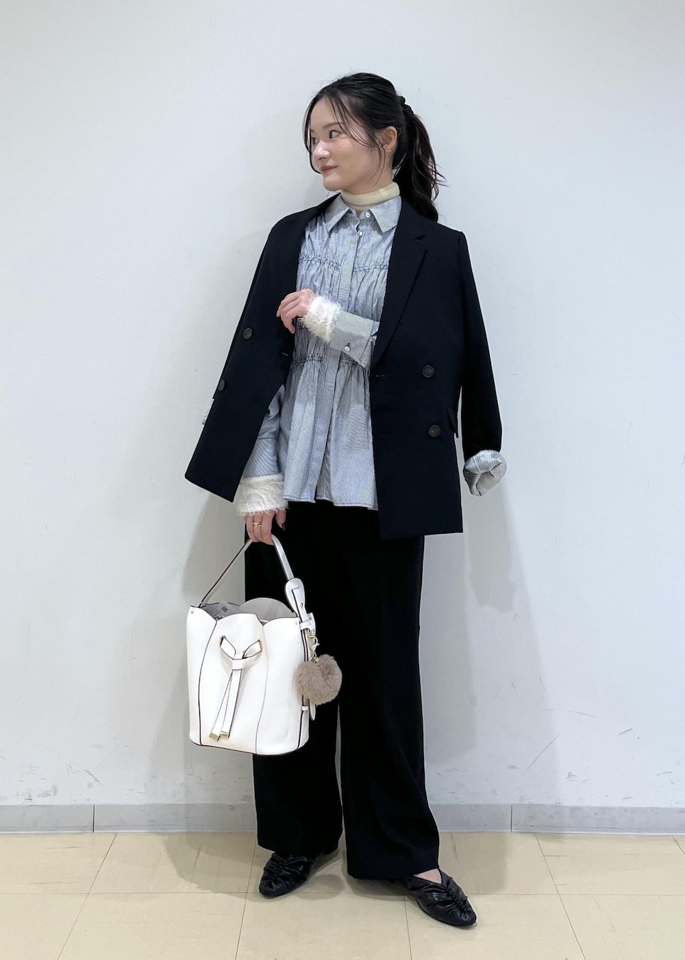 ブラック系のスラックス、ブラック系のテーラードジャケット、ブラック系のパンプスを着用したレディースの秋コーディネートの7枚目の写真