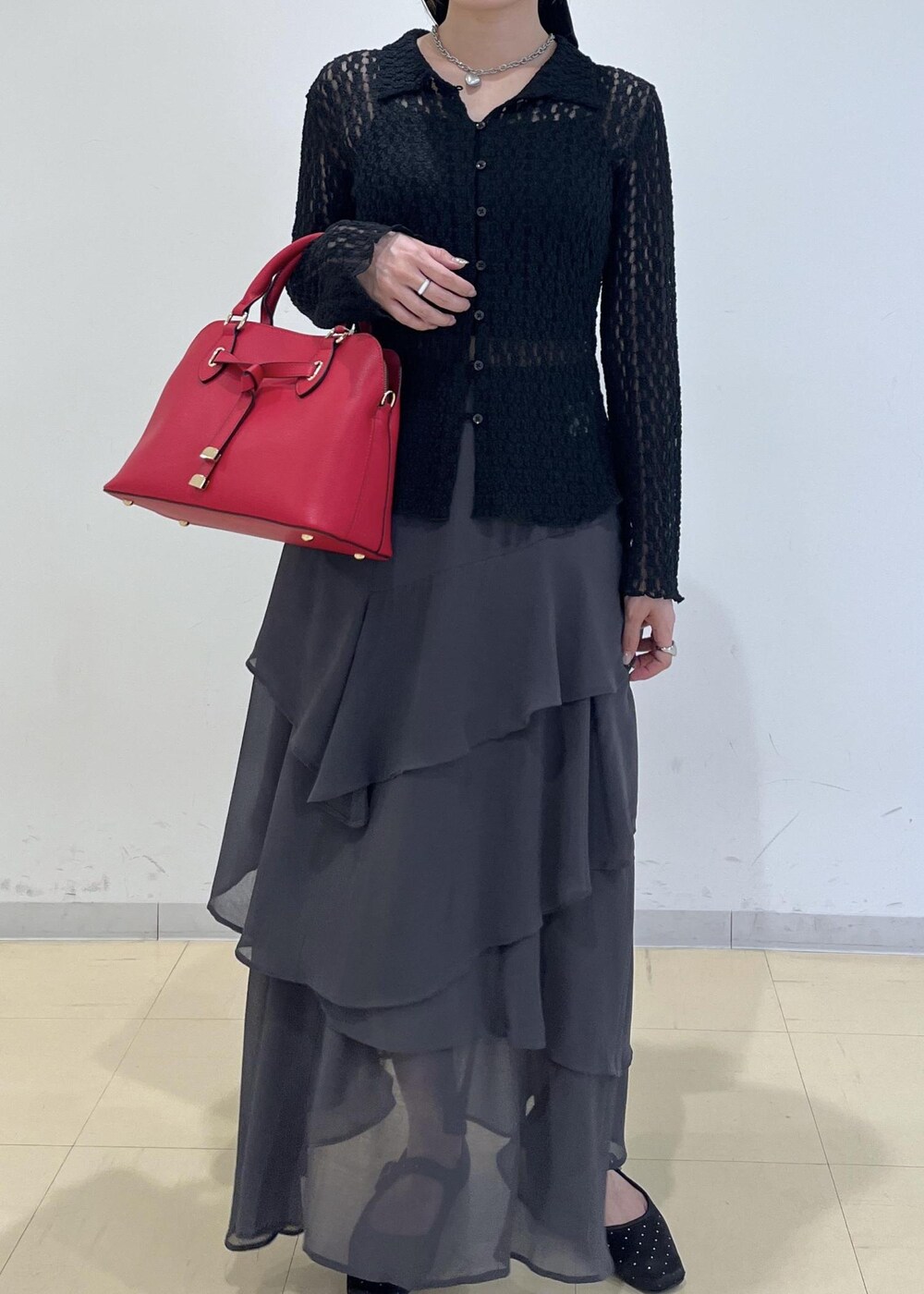 ブラック系のカーディガン/ボレロ、レッド系のボストンバッグ、グレー系のスカートを着用したレディースの秋コーディネートの9枚目の写真