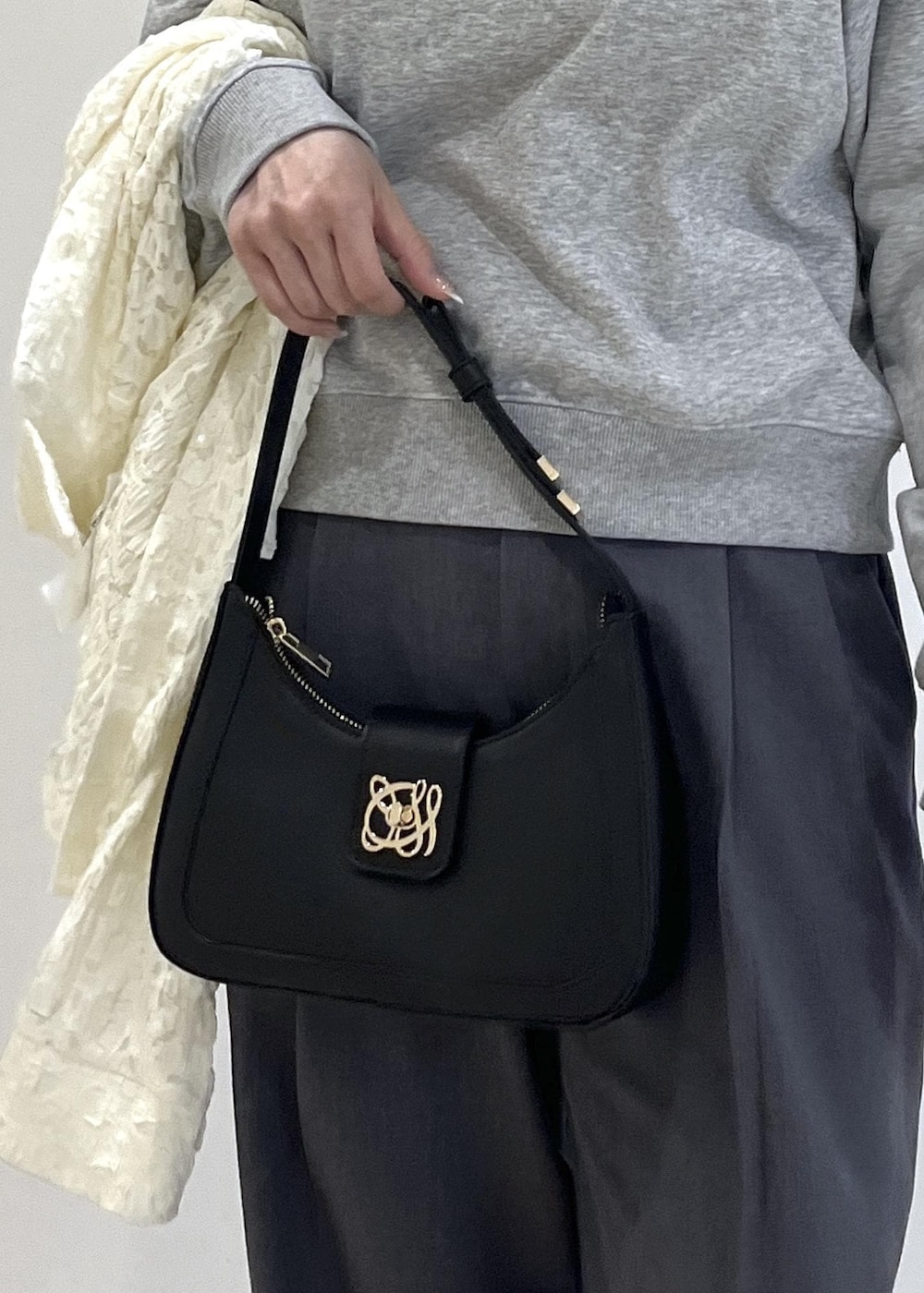 ホワイト系のパンプス、ブラック系のショルダーバッグ、ホワイト系のカーディガン/ボレロを着用したレディースの春コーディネートの9枚目の写真