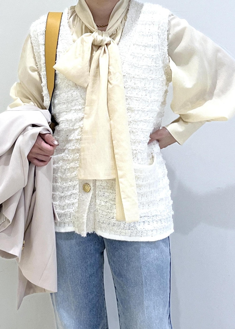 イエロー系のトートバッグ、ベージュ系のローファー、ベージュ系のテーラードジャケットを着用したレディースの冬コーディネートの3枚目の写真