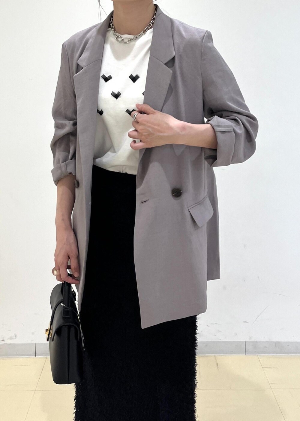 ホワイト系のTシャツ/カットソー、グレー系のテーラードジャケット、ブラック系のサンダルを着用したレディースの夏コーディネートの5枚目の写真