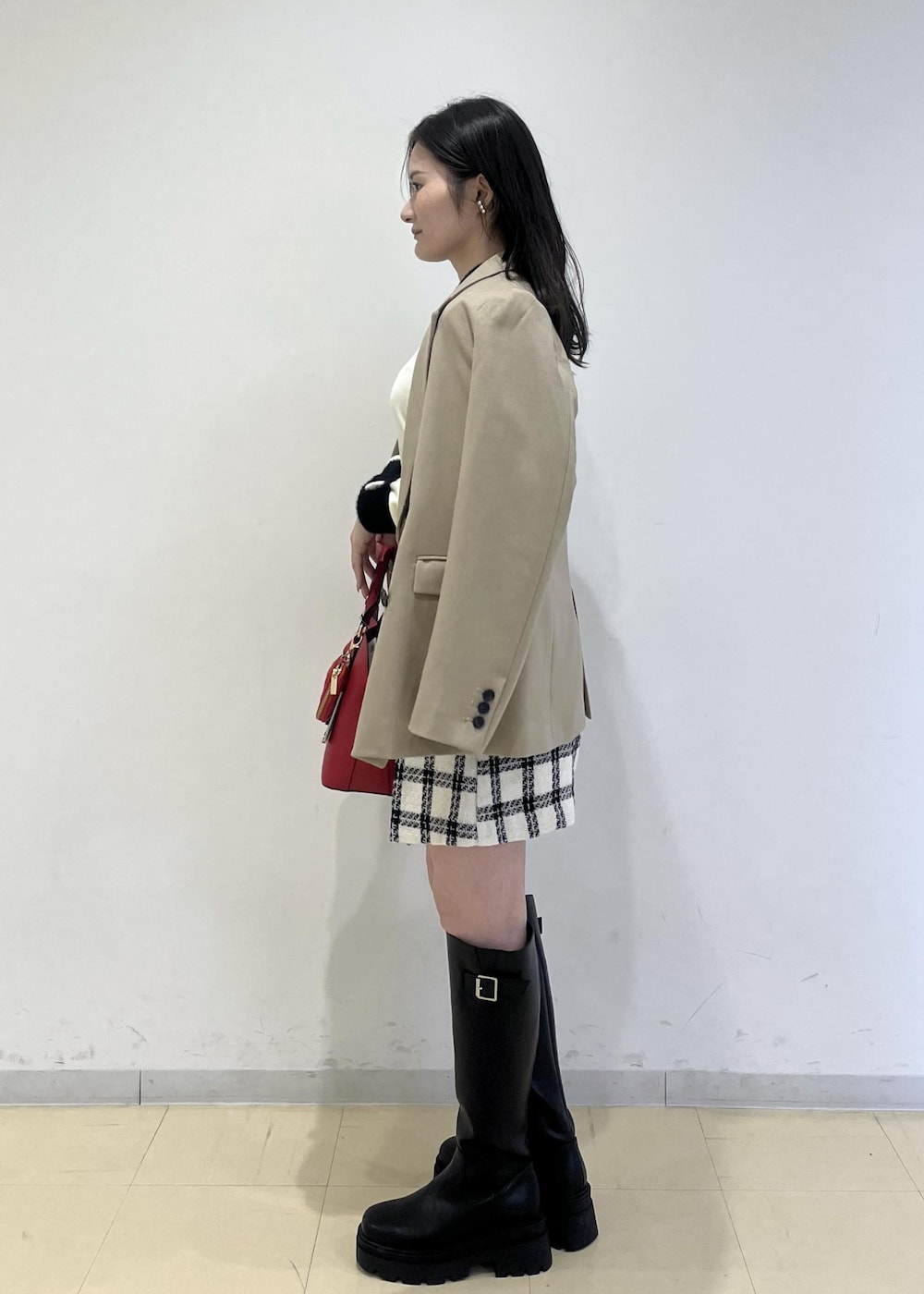 ブラック系のブーツ、ホワイト系のスカート、ホワイト系のニット/セーターを着用したレディースの冬コーディネートの3枚目の写真