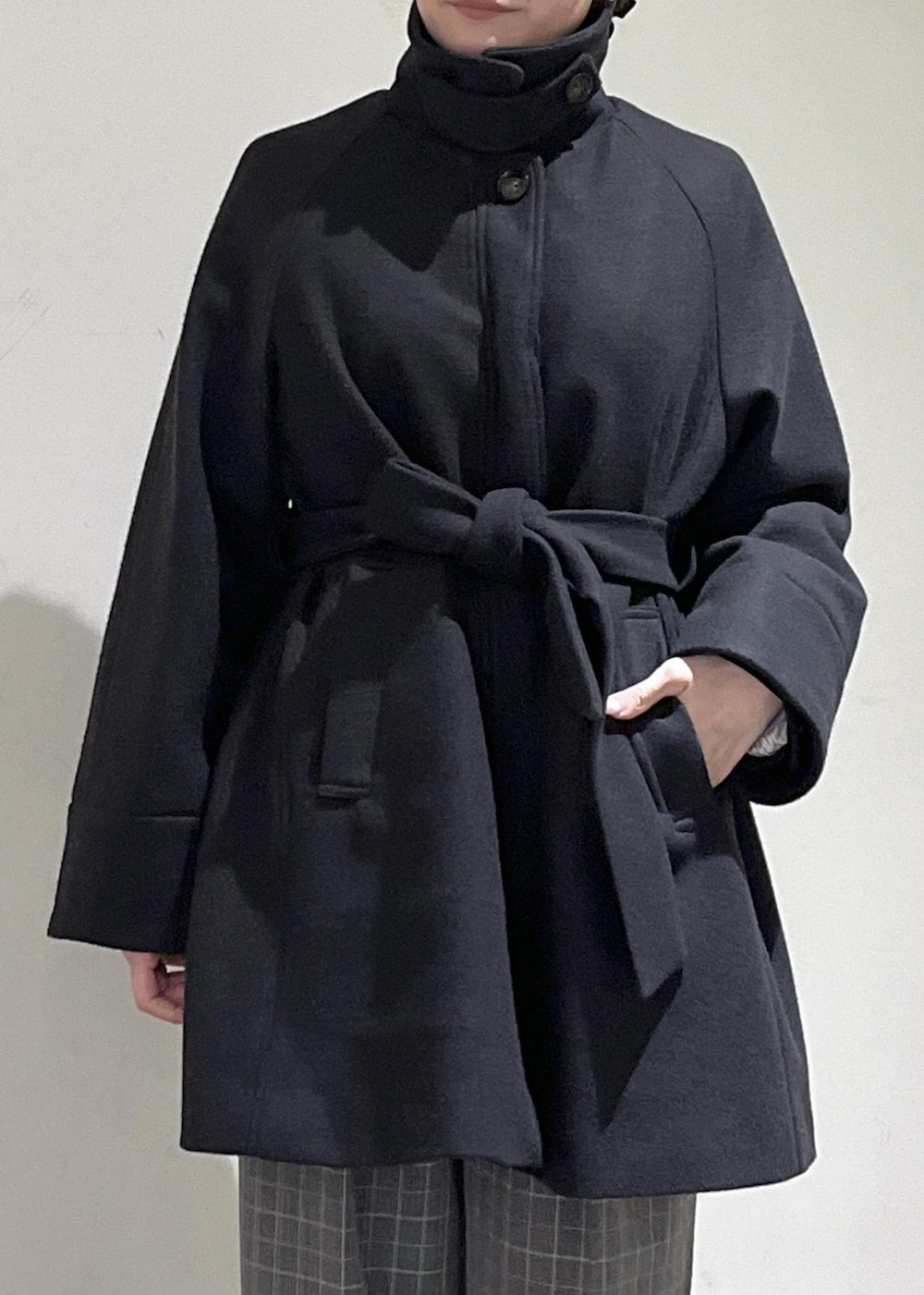 ベージュ系のトートバッグ、ブラック系のテーラードジャケット、ブラック系のチェスターコートを着用したレディースの冬コーディネートの8枚目の写真