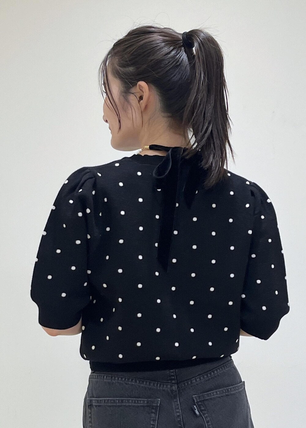 ピンク系のショルダーバッグ、ブラック系のパンプス、ブラック系のニット/セーターを着用したレディースの秋コーディネートの6枚目の写真