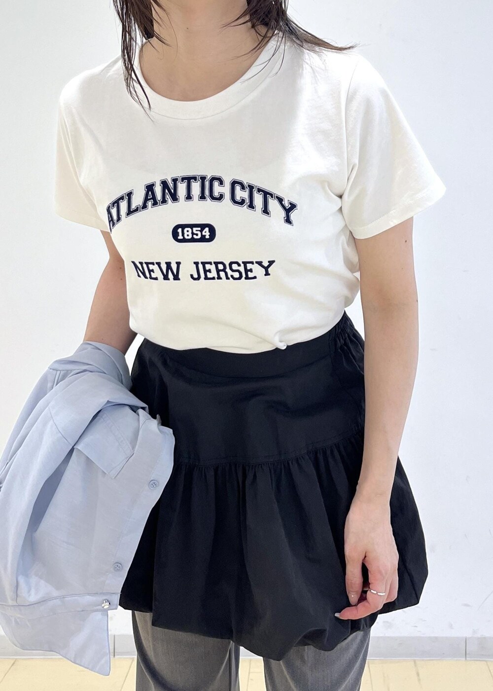 ブラック系のパンプス、ブラック系のスカート、ブルー系のシャツ/ブラウスを着用したレディースの春コーディネートの8枚目の写真