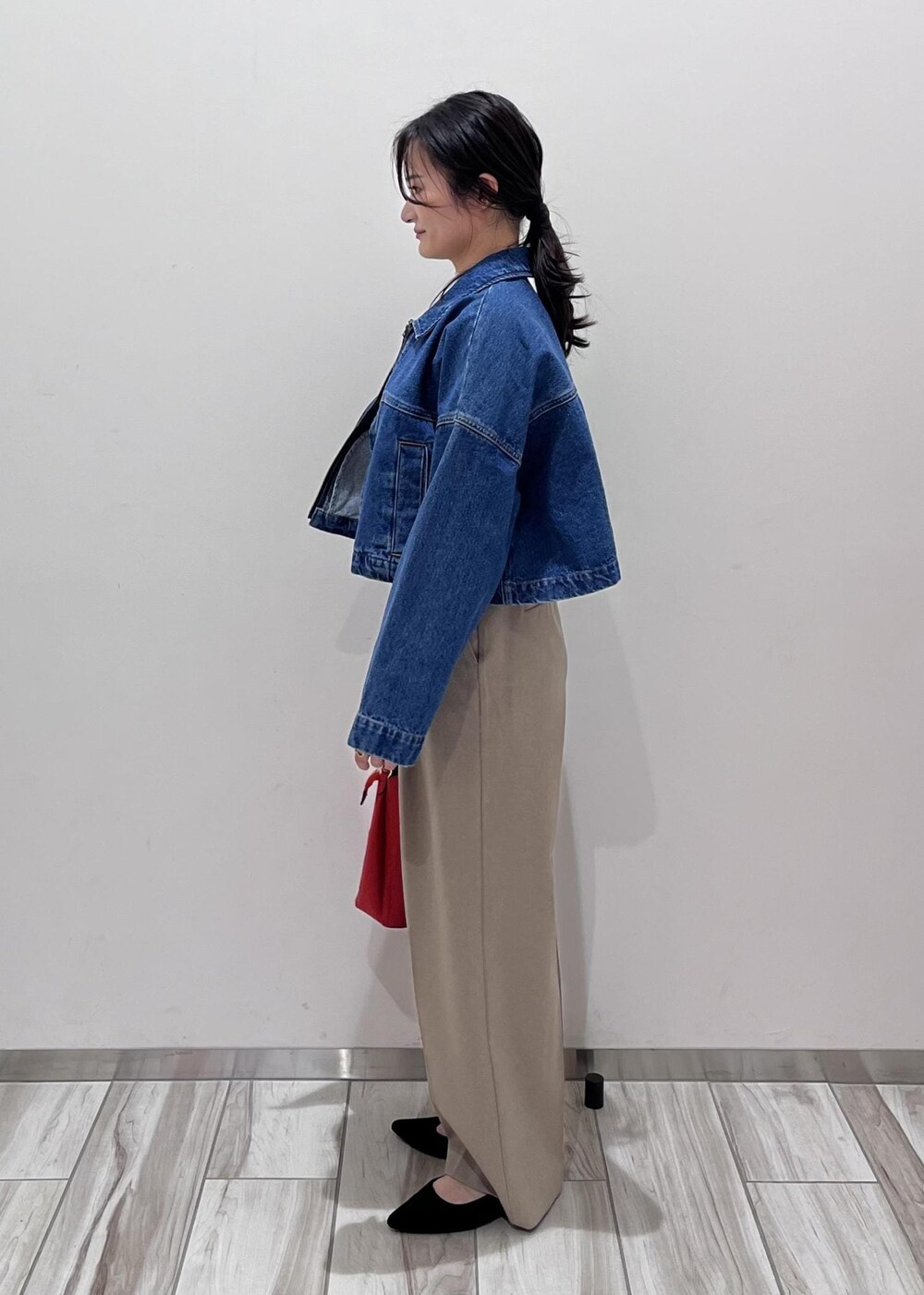 ブルー系のデニムジャケット、ホワイト系のニット/セーター、ベージュ系のスラックスを着用したレディースの冬コーディネートの3枚目の写真