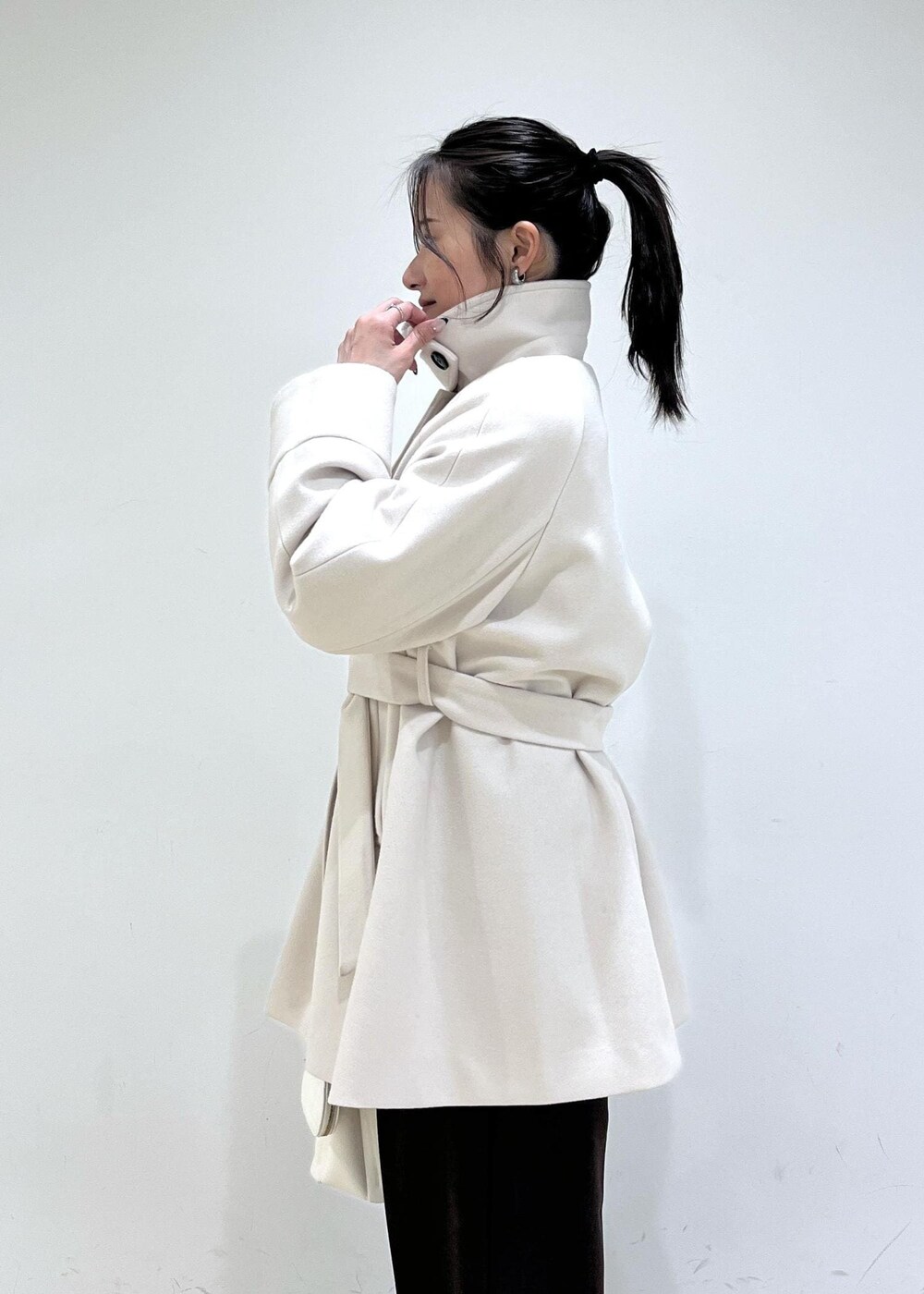 ブラウン系のスラックス、ベージュ系のチェスターコート、ベージュ系のブーツを着用したレディースの冬コーディネートの8枚目の写真