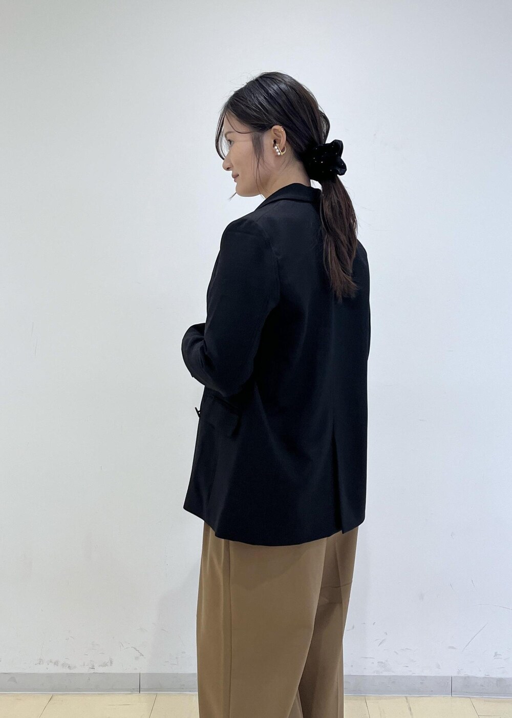 ブラック系のショルダーバッグ、ブラック系のテーラードジャケット、イエロー系のその他パンツを着用したレディースの秋コーディネートの5枚目の写真