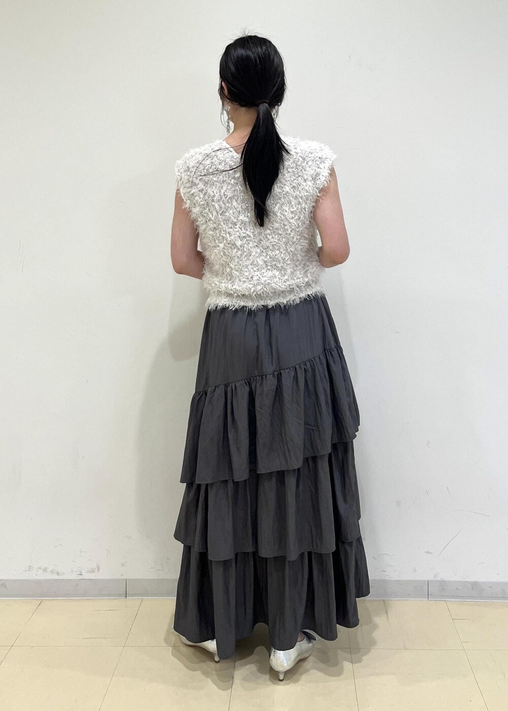 シルバー系のパンプス、シルバー系のショルダーバッグ、グレー系のスカートを着用したレディースの夏コーディネートの3枚目の写真