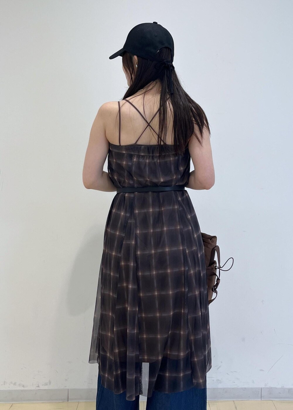 ブルー系のデニムパンツ、ブラウン系のスカート、ブラウン系のキャミソールを着用したレディースの夏コーディネートの8枚目の写真
