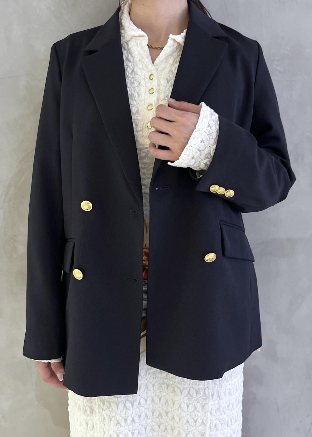 ブラック系のパンプス、ホワイト系のワンピース、ブルー系のテーラードジャケットを着用したレディースの春コーディネートの8枚目の写真