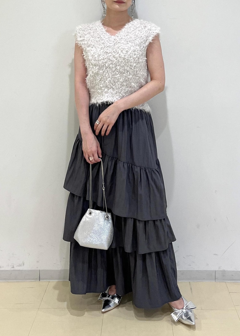 シルバー系のパンプス、シルバー系のショルダーバッグ、グレー系のスカートを着用したレディースの夏コーディネートの4枚目の写真