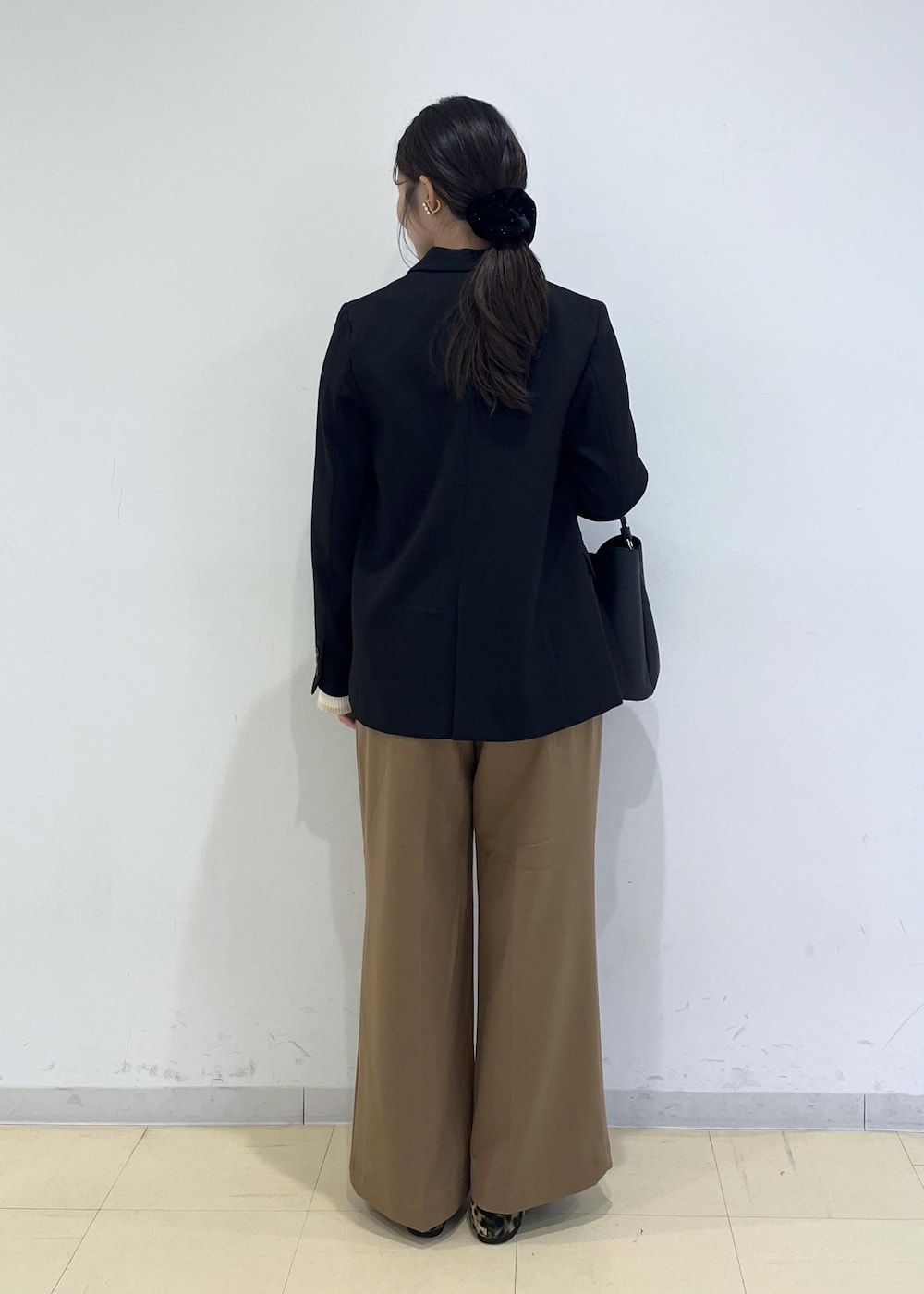 ブラック系のショルダーバッグ、ブラック系のテーラードジャケット、イエロー系のその他パンツを着用したレディースの秋コーディネートの4枚目の写真