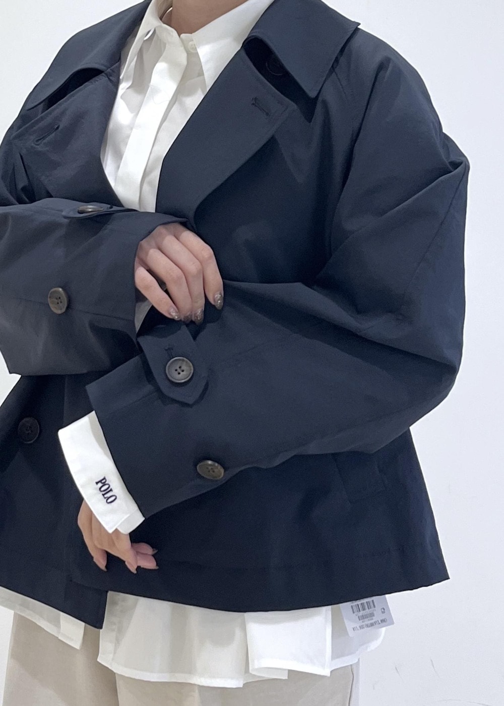 ブラック系のパンプス、ベージュ系のショルダーバッグ、ブルー系のトレンチコートを着用したレディースの春コーディネートの9枚目の写真