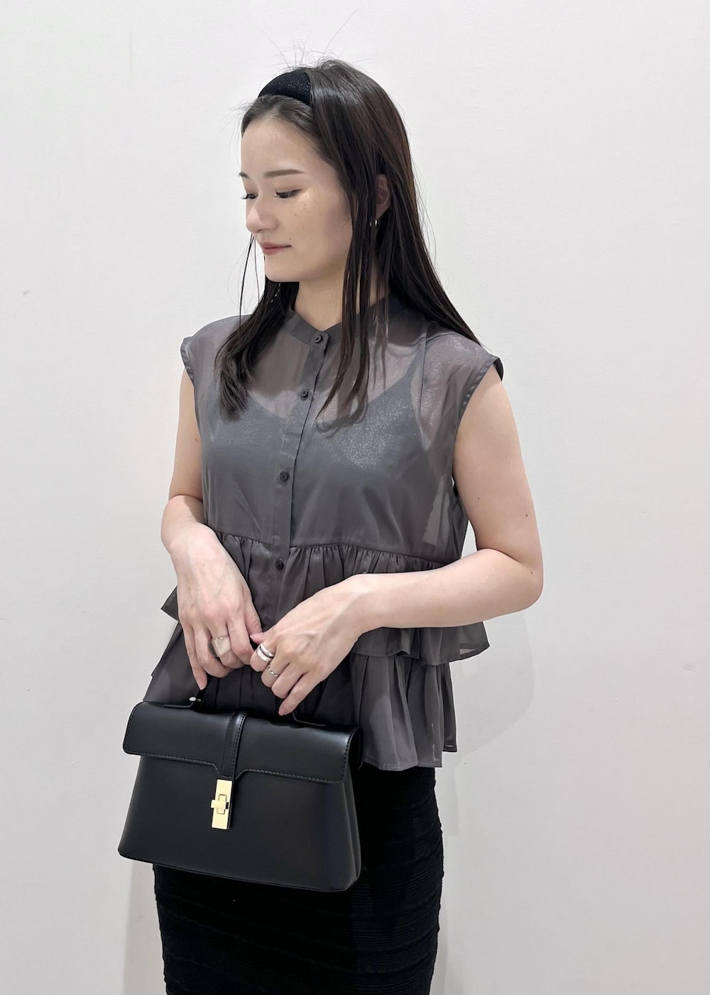 ブラック系のスカート、グレー系のシャツ/ブラウス、ブラック系のショルダーバッグを着用したレディースの夏コーディネートの3枚目の写真