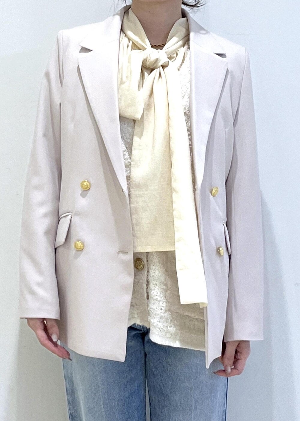 イエロー系のトートバッグ、ベージュ系のローファー、ベージュ系のテーラードジャケットを着用したレディースの冬コーディネートの5枚目の写真