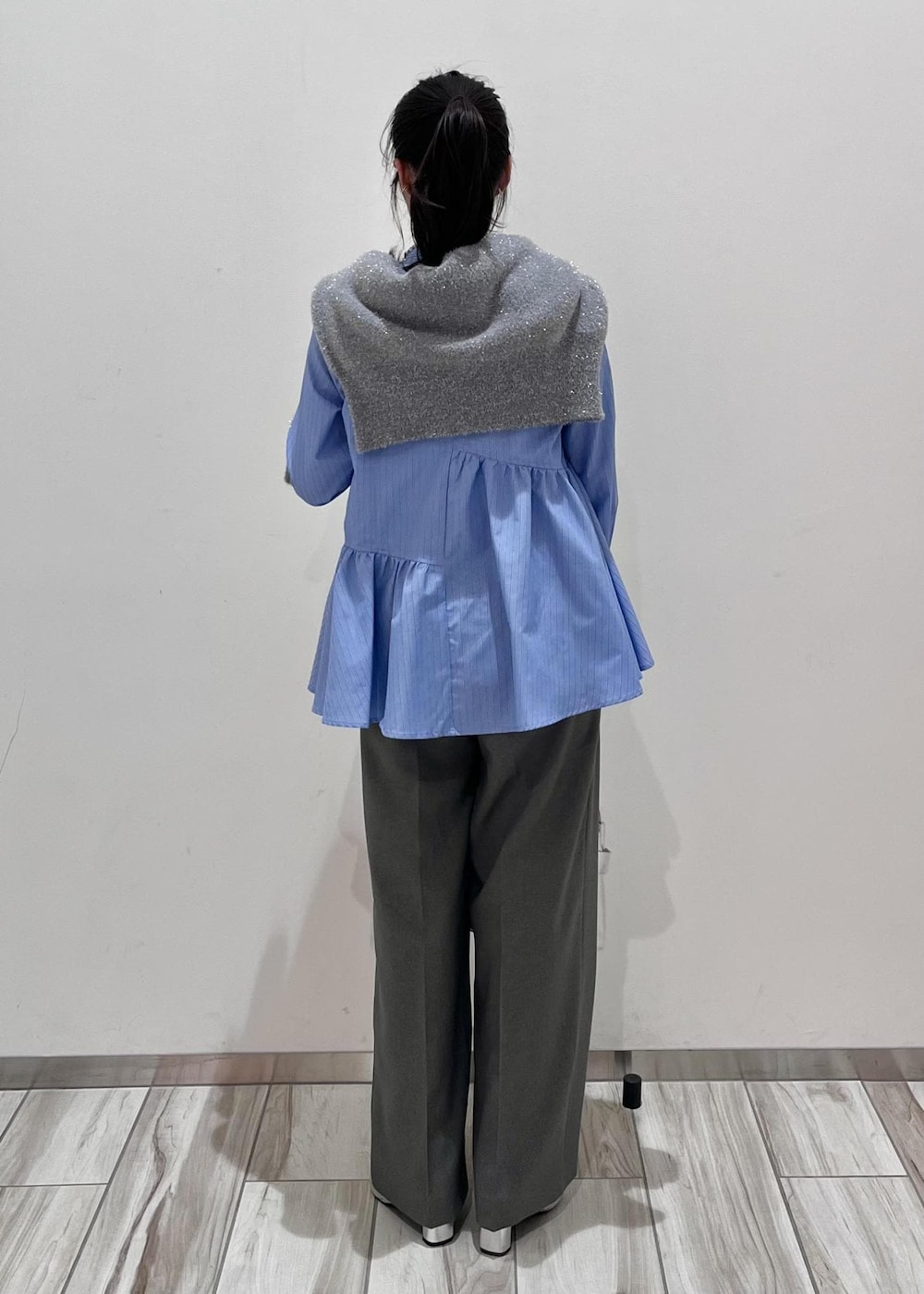 シルバー系のショルダーバッグ、シルバー系のブーツ、グレー系のスラックスを着用したレディースの冬コーディネートの3枚目の写真