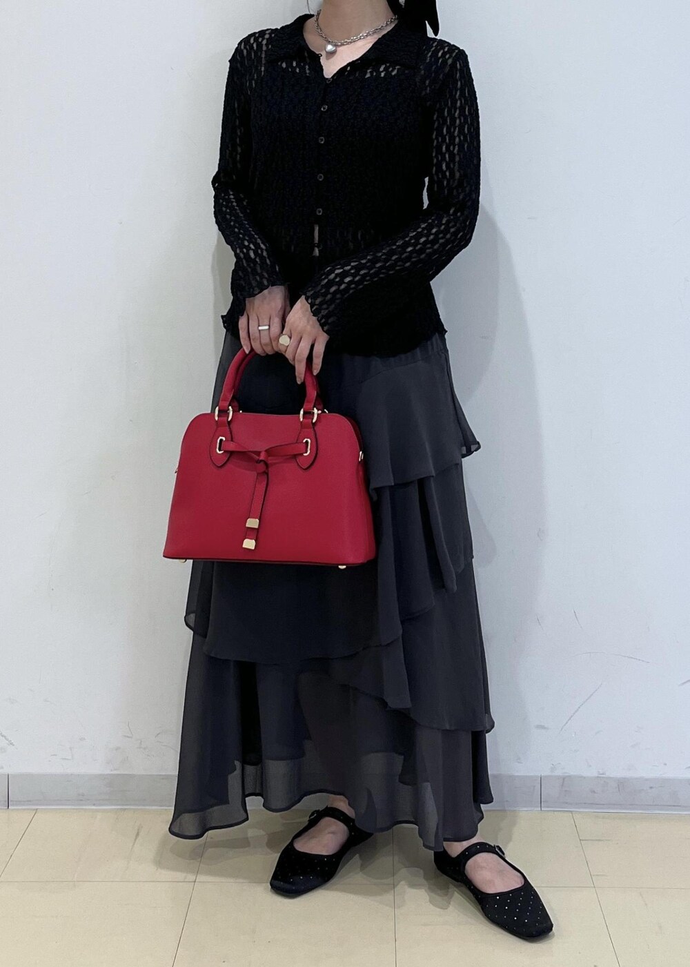 ブラック系のカーディガン/ボレロ、レッド系のボストンバッグ、グレー系のスカートを着用したレディースの秋コーディネートの10枚目の写真
