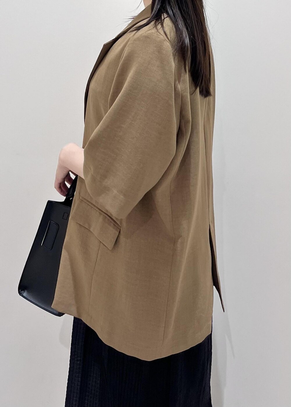 ブラック系のサンダル、ブラック系のハンドバッグ、ブラウン系のテーラードジャケットを着用したレディースの夏コーディネートの4枚目の写真