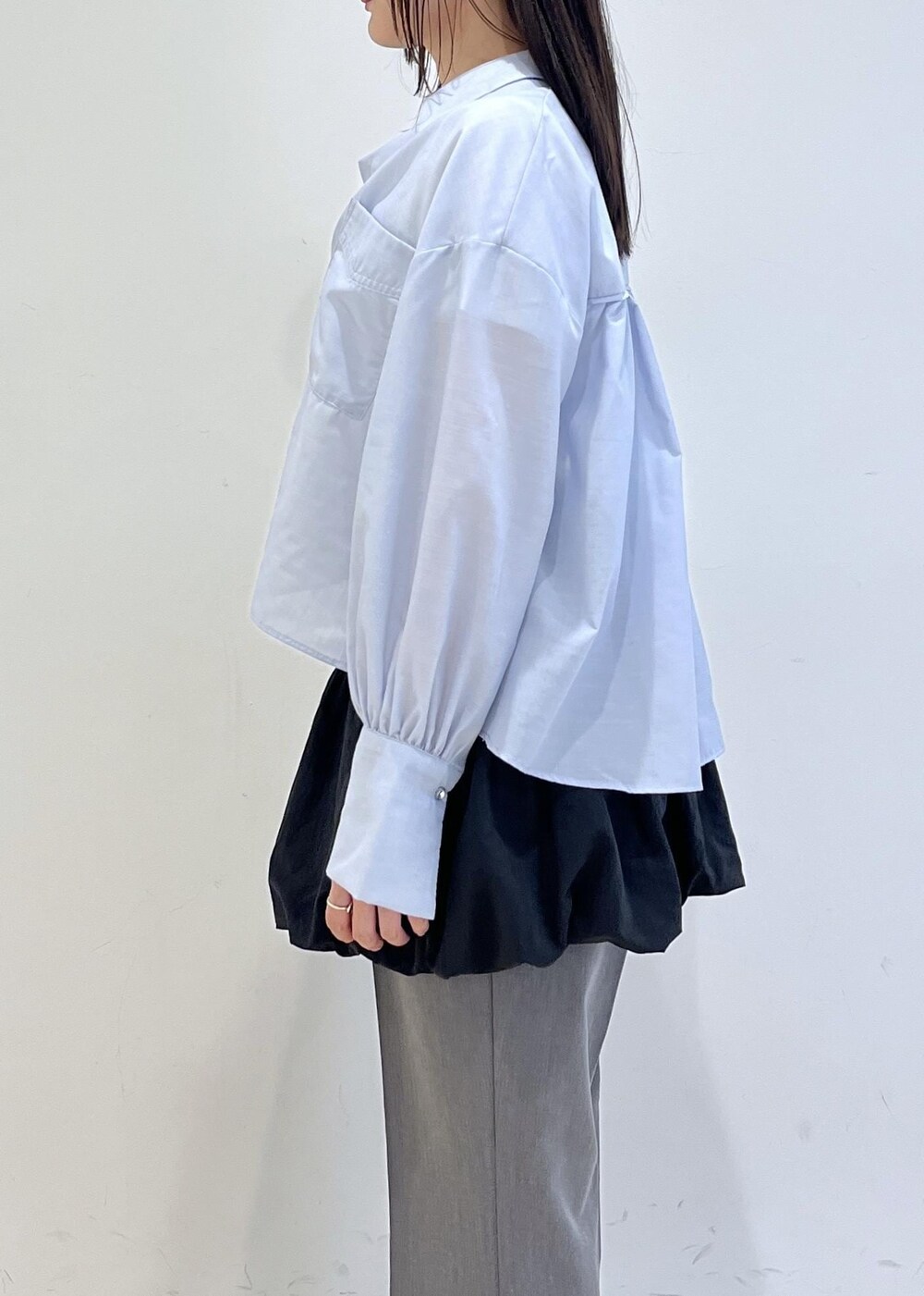 ブラック系のパンプス、ブラック系のスカート、ブルー系のシャツ/ブラウスを着用したレディースの春コーディネートの4枚目の写真