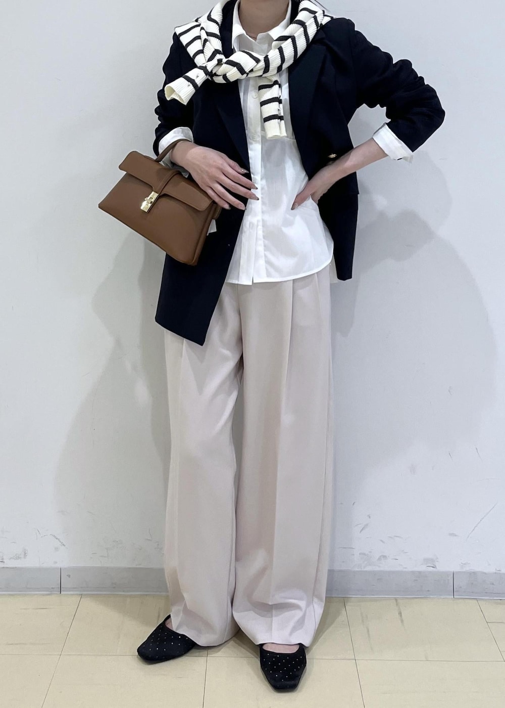 ホワイト系のシャツ/ブラウス、ホワイト系のニット/セーター、ブルー系のテーラードジャケットを着用したレディースの冬コーディネートの3枚目の写真