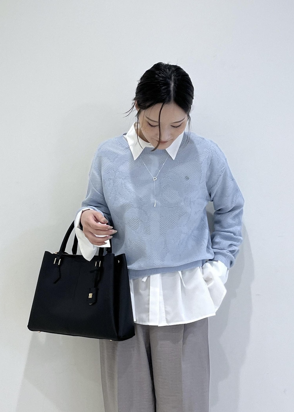 ブラック系のパンプス、グレー系のその他パンツ、ホワイト系のシャツ/ブラウスを着用したレディースの春コーディネートの5枚目の写真