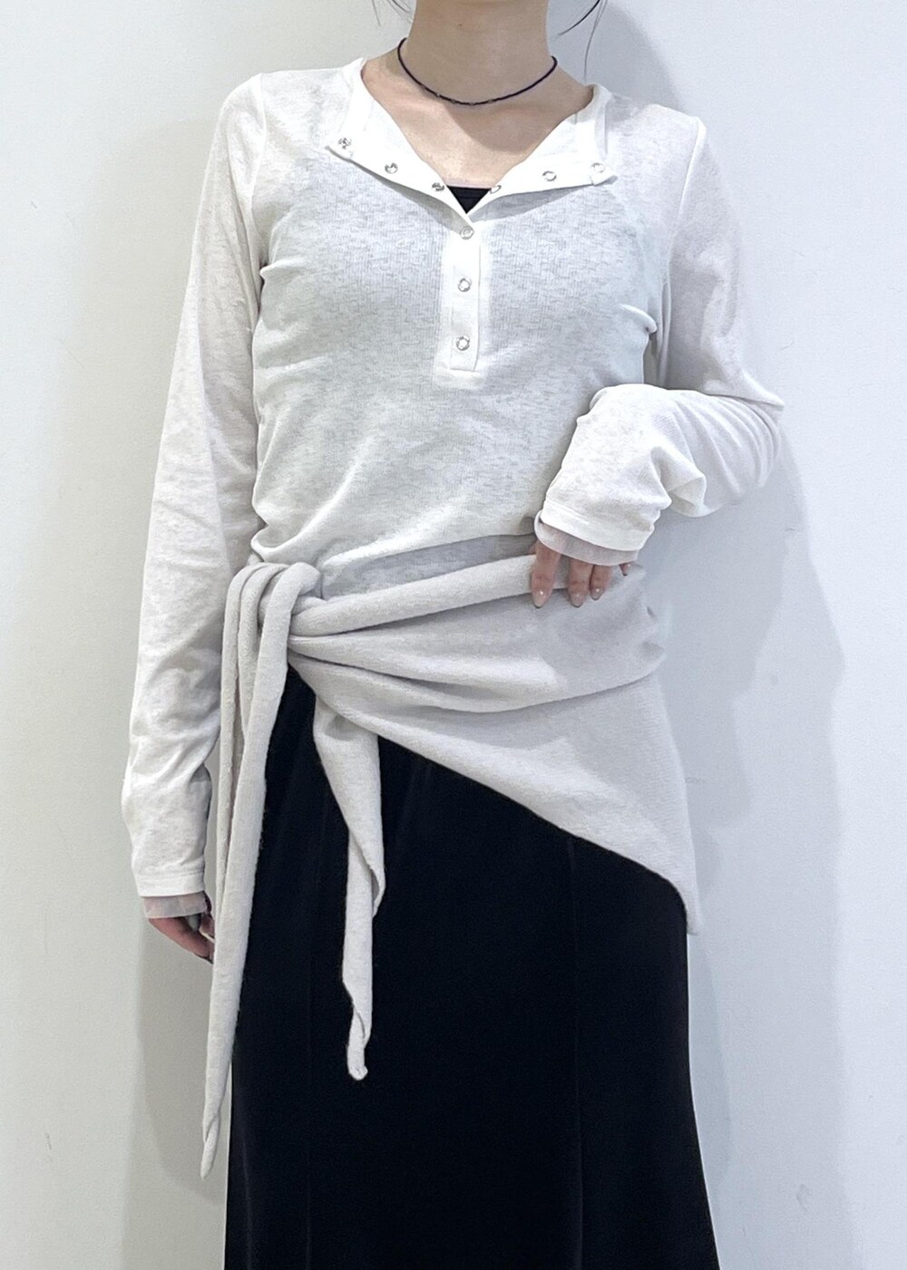 ホワイト系のTシャツ/カットソー、ブラック系のブーツ、ブラック系のスカートを着用したレディースの秋コーディネートの8枚目の写真
