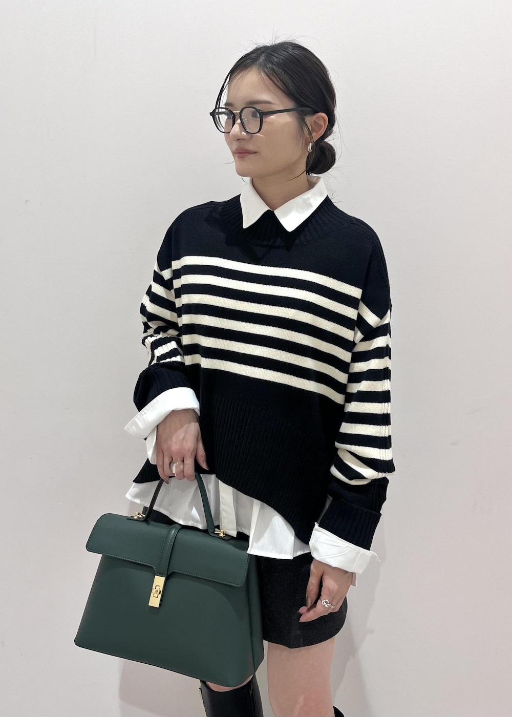 ブラック系のブーツ、ホワイト系のシャツ/ブラウス、ブラック系のニット/セーターを着用したレディースの秋コーディネートの6枚目の写真