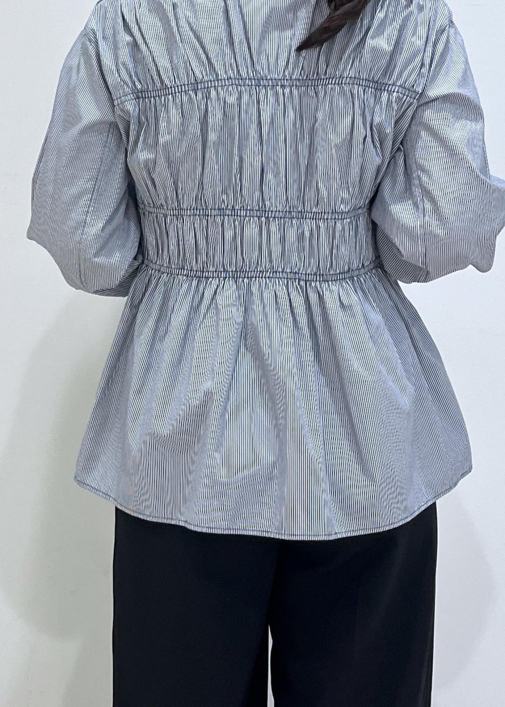 ブラック系のスラックス、ブラック系のテーラードジャケット、ブラック系のパンプスを着用したレディースの秋コーディネートの5枚目の写真