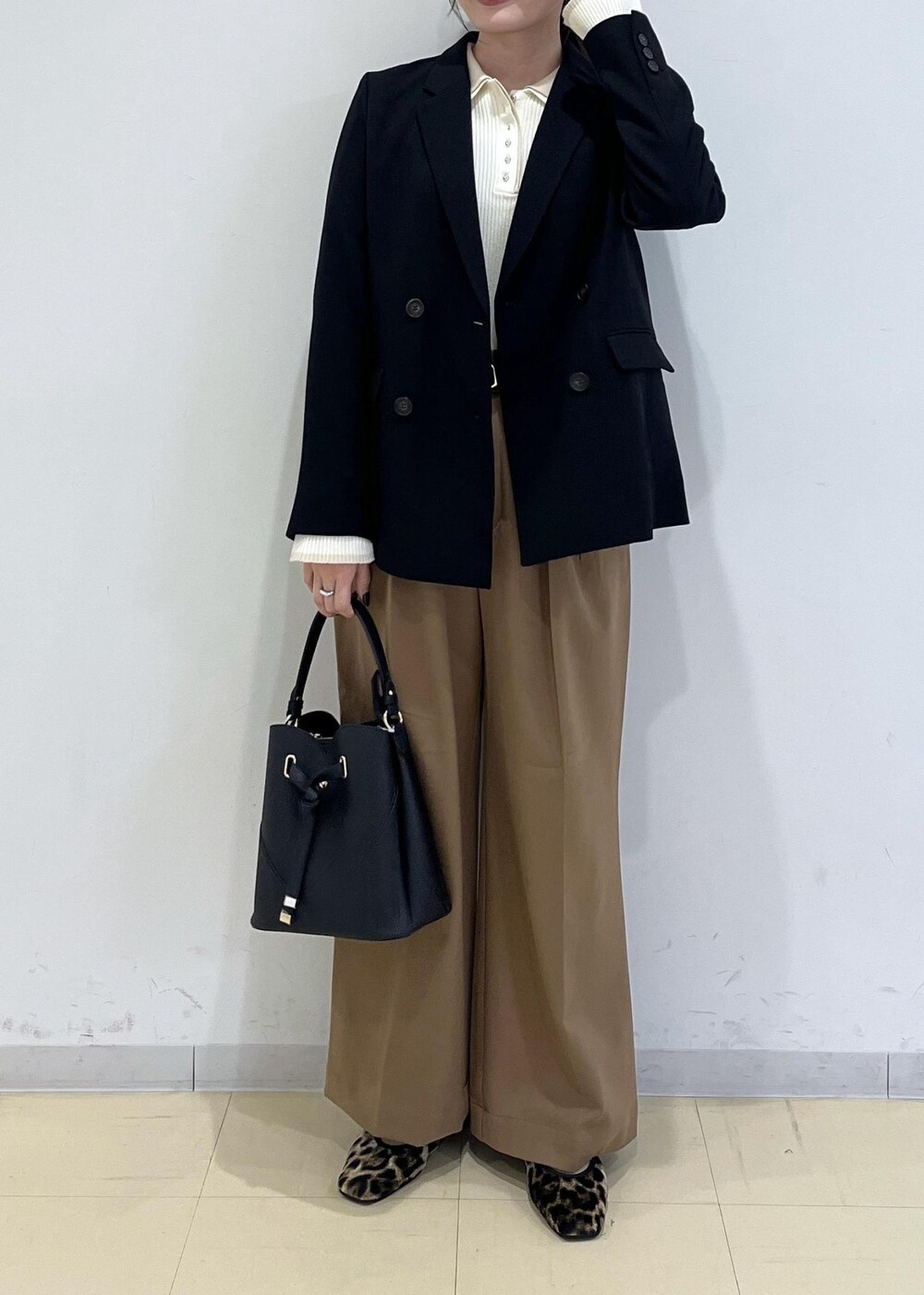 ブラック系のショルダーバッグ、ブラック系のテーラードジャケット、イエロー系のその他パンツを着用したレディースの秋コーディネートの3枚目の写真