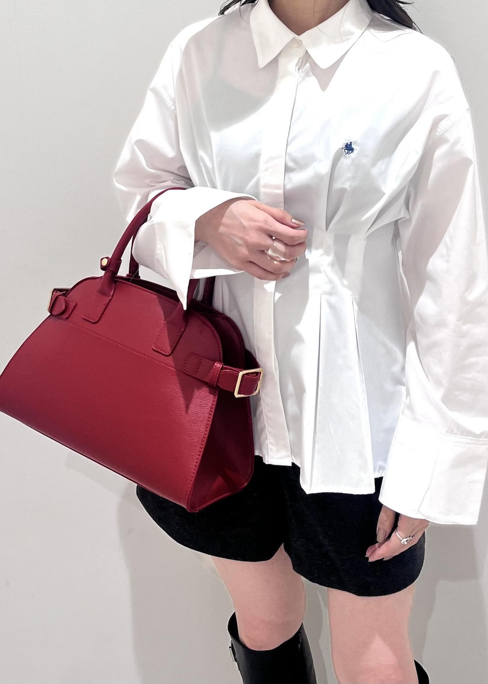 レッド系のトートバッグ、グレー系のその他パンツ、ブラック系のブーツを着用したレディースの秋コーディネートの8枚目の写真